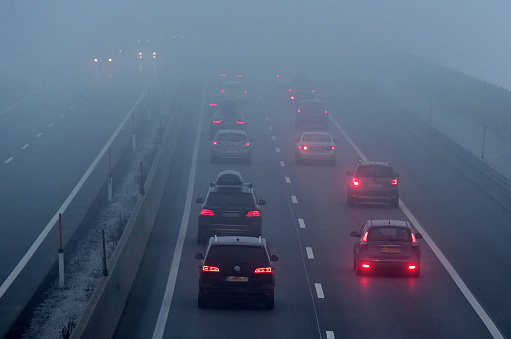 A motorway in Austria in the fog with many lights of cars