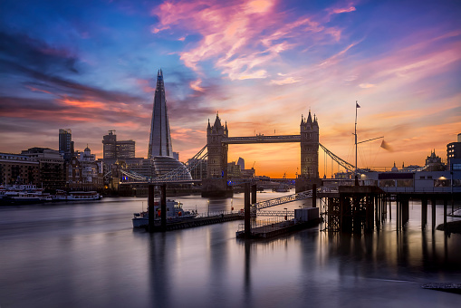 Beautiful sunset view to the skyline of London, United Kingdom, with the famous Tower Bridge and modern skyscrapers along the Thames river