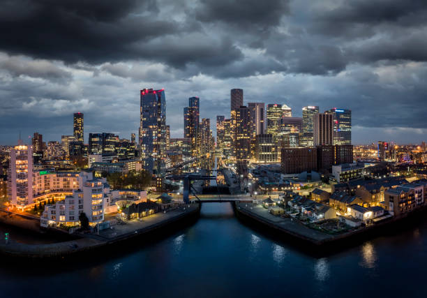 i grattacieli illuminati del quartiere finanziario canary wharf al crepuscolo - canary wharf foto e immagini stock