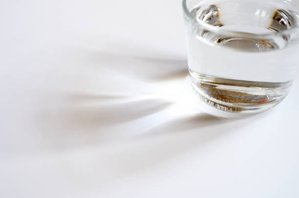 istock a glass cup of clear water on white background and reflection from the light. space for text 1311153420