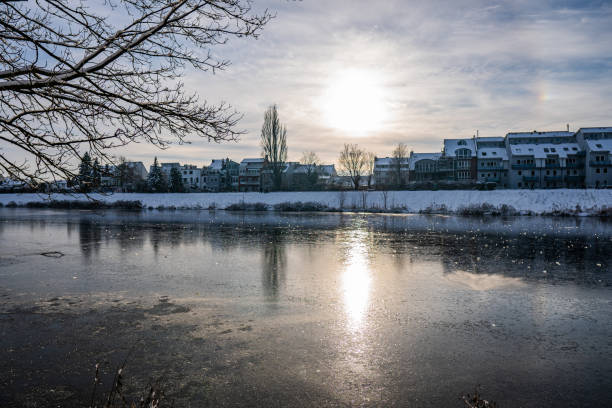 istock sun reflecting at beautiful frozen river called werdersee at sunny warm white winter day with snowy dike in bremen in the evening 1311155721