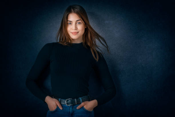 istock Attractive young woman studio portrait while standing at isolated dark background 1311157273