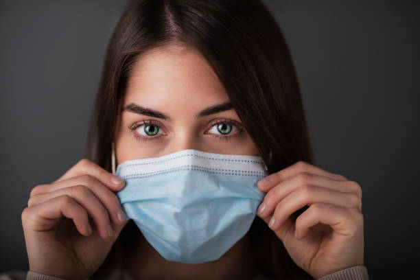 istock Young woman studio portrait while wearing face mask 1311157286