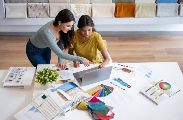 istock Designer talking to a client and watching some design sketches at her atelier 1311157891