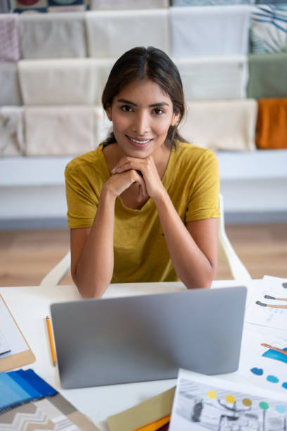 istock Business owner working at a fabric shop using her laptop and smiling 1311157896