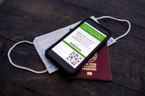 istock Smartphone displaying a valid COVID-19 vaccination certificate with passport and protective face mask. 1311158516