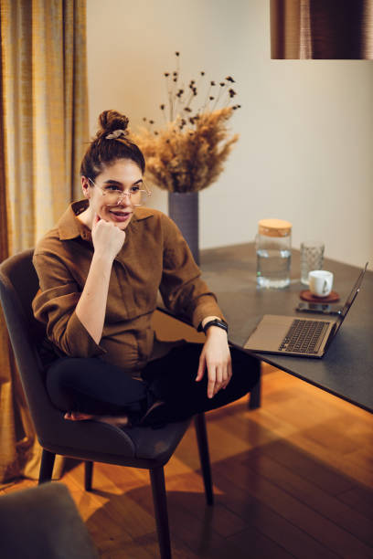 istock Smiling pregnant freelancer sitting at dining table at home and taking a break from work during quarantine. 1311159826
