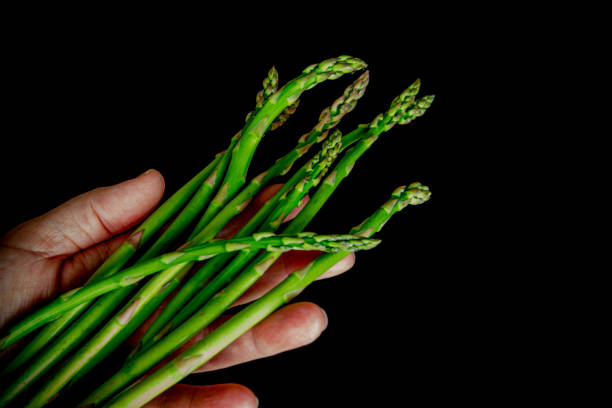 istock bunch of green asparagus on black background 1311163438