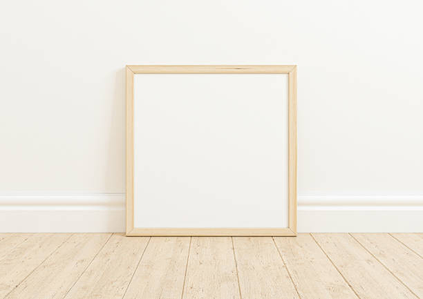 istock Single 10x10 Square wooden Frame mockup on wooden floor and white wall. 1311164849