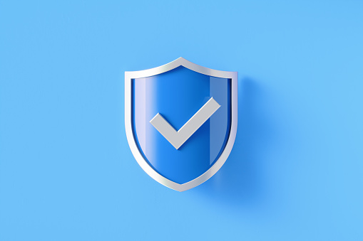 Silver shield with check mark symbol sitting on blue background, Horizontal composition with copy space.