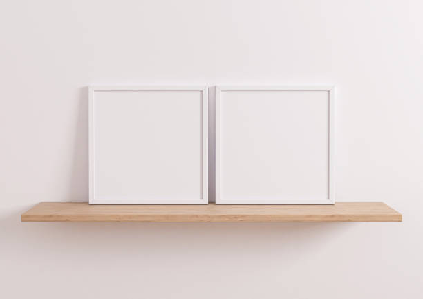 istock Double 10x10 Square white Frame mockup on wooden shelf and white wall. 1311165523