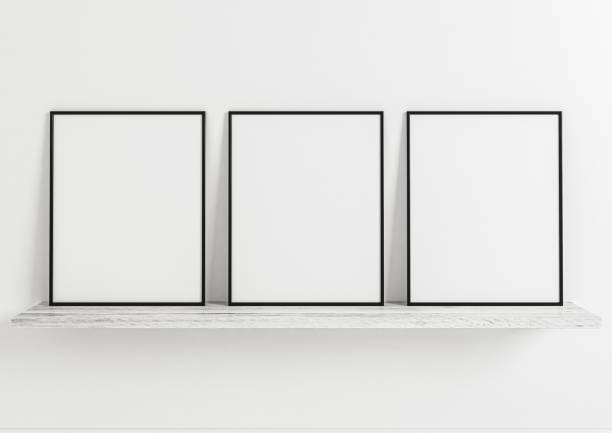istock Triple 8x10 Vertical Black Frame mockup on white wooden shelf and white wall. 1311165682