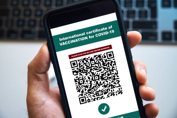istock man holding a smartphone with certificate of vaccination 1311166059