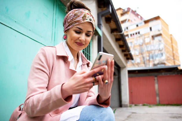 istock Beautiful young woman using smart phone 1311167756