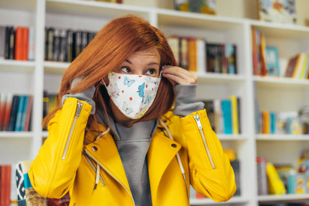 istock Woman putting a face protective mask 1311167860