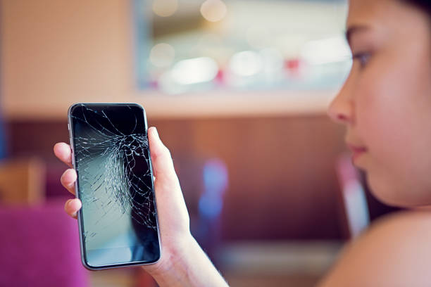 istock Sad girl is watching her broken mobile phone 1311168215