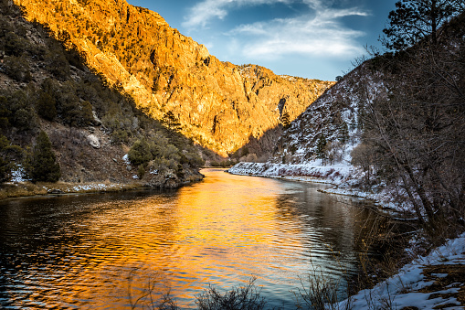 The Gunnison river in the evening light with golden reflections on the water