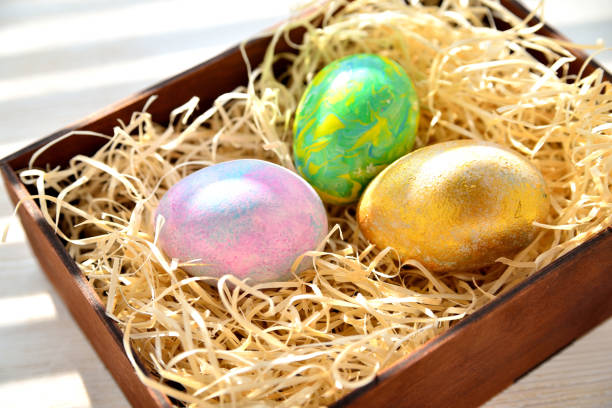 istock Three colored chicken eggs in a box with shavings in the sunlight 1311171107