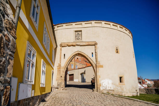 Zatecky Barbican, Medieval gothic fortification, fortress wall, sunny day, town gate, old stronghold, city coat of arms, renaissance yellow historical building, Kadan, Czech Republic, April 04, 2021 zatecky barbican, fortificación gótica medieval, muralla de la fortaleza, día soleado, puerta de la ciudad, antiguo bastión, escudo de armas de la ciudad, edificio histórico amarillo renacentista, kadan, república checa, 04 de abril de 2021