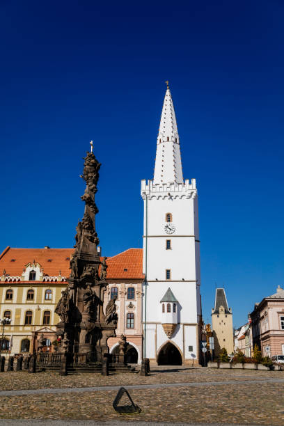 istock Holy Trinity Column with baroque sculptural group, Main town Peace square, gothic city hall tower, Medieval renaissance historical buildings, Mikulov Gate, Kadan, Czech Republic, April 04, 2021 1311173427