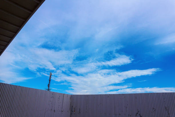 Low angle view of fence against blue sky in the afternoon