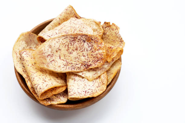 istock Crispy taro chips in wooden bowl on white 1311175788