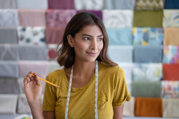 Happy saleswoman working at a fabric shop Portrait of a happy Latin American saleswoman working at a fabric shop and smiling - small business concepts fabric shop stock pictures, royalty-free photos & images