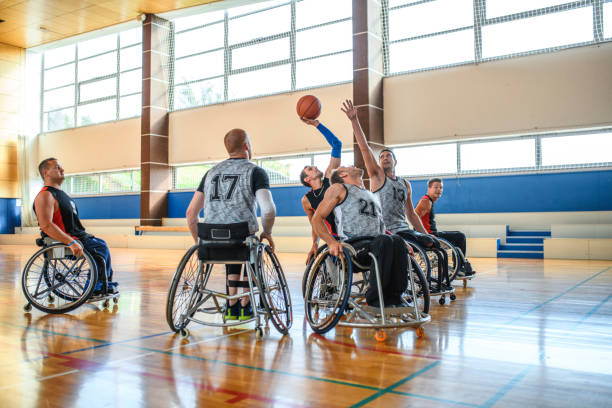 Male Wheelchair Basketball Players Struggling for Ball Aggressive male wheelchair basketball players struggling for control of ball during practice game. athlete with disabilities photos stock pictures, royalty-free photos & images
