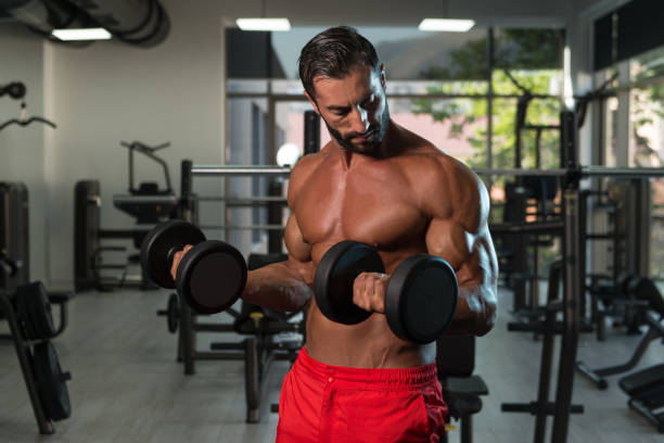 istock Biceps Exercise With Dumbbells In A Gym 1311186076