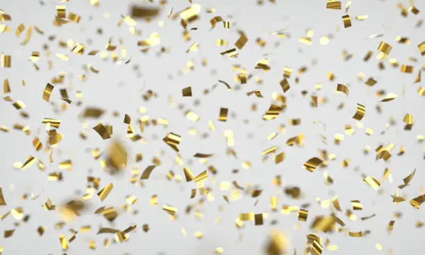 Shiny confetti with depth of field on light grey background