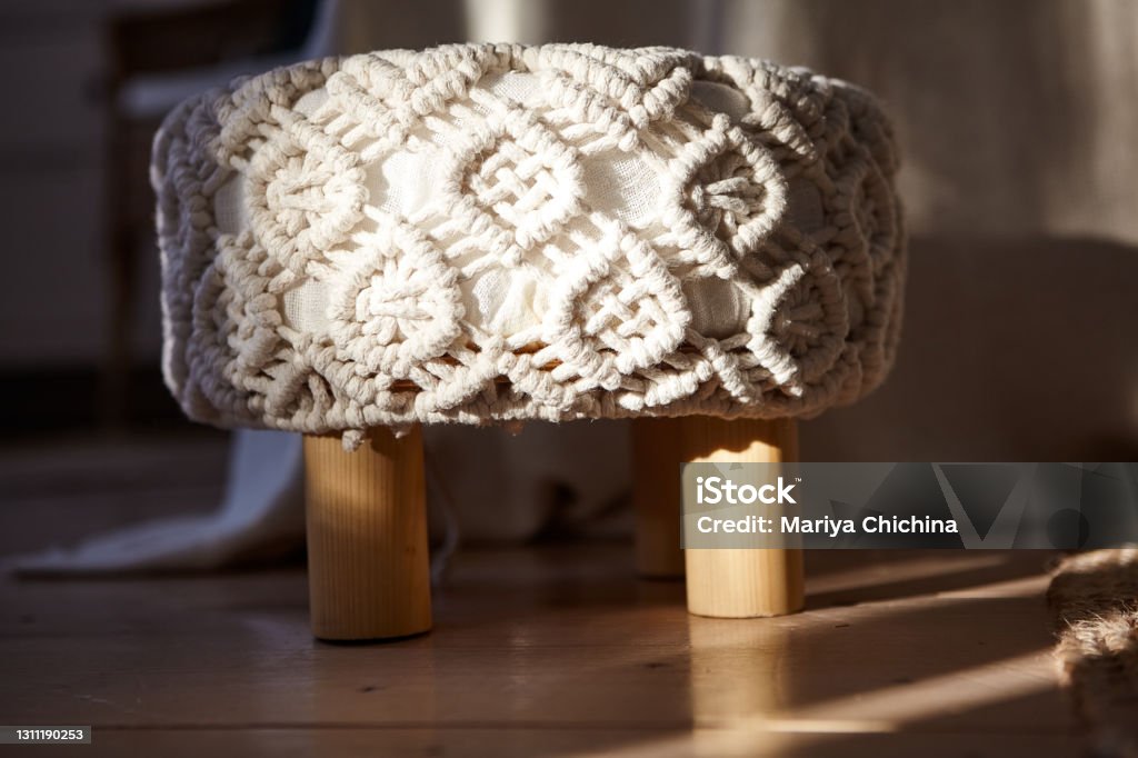 A small chair with a macrame-style seat. Bright bedroom in a modern style. Macrame Stock Photo