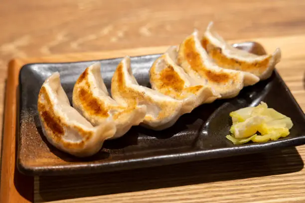 Gyoza (dumpling).Baked gyoza.
Chewy dough.
A table at an izakaya.
Dumplings arranged on a plate.
Six for one person. Accompanied by Chinese cabbage pickles.
Taken in Japan.