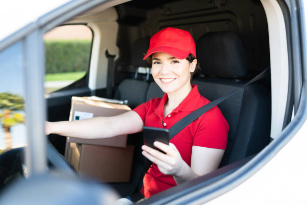 istock Female courier using his smartphone inside a delivery truck 1311192256