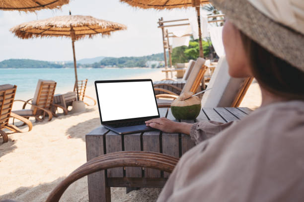 istock a woman using and touching on laptop touchpad with blank desktop screen while sitting on the beach 1311192453