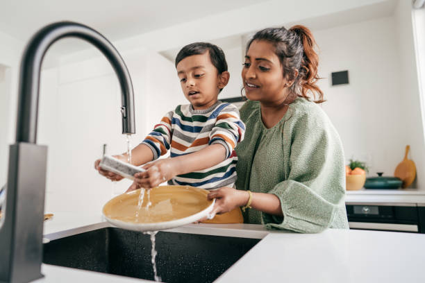 Keeping kids busy Mom and child washing dishes together chores stock pictures, royalty-free photos & images
