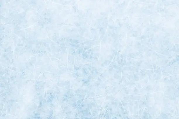 Photo of Ice blue background with ice skating tracks.