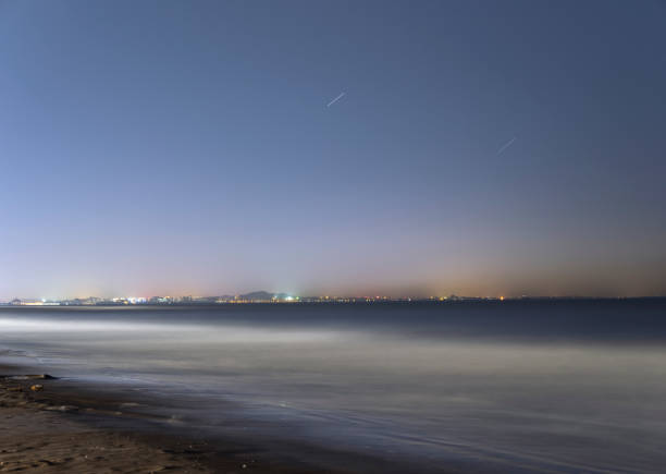 istock Aranya Sea and city lights at night 1311203200