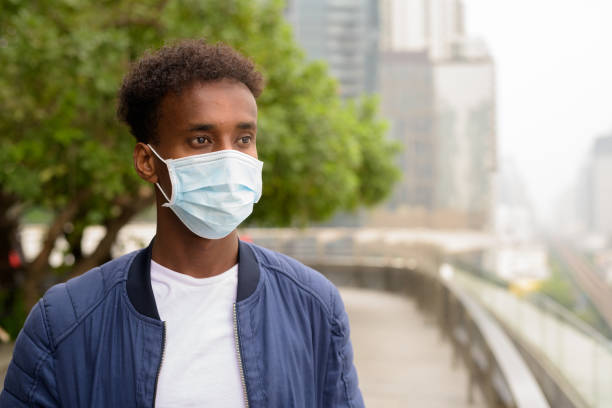 istock Handsome black African man wearing face mask and thinking 1311205390