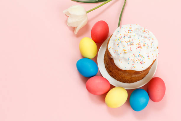 istock Easter cake on a plate, eggs and tulip flower with pink background. 1311207008