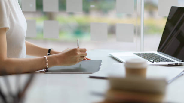 istock Side view of female student hand using digital tablet to do homework in library 1311207720