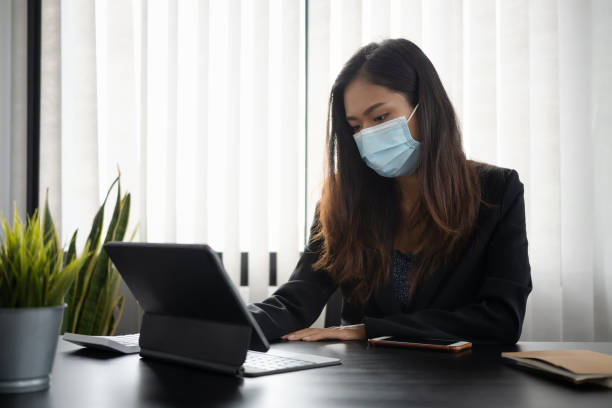 istock Businesswoman in protective mask concentrate working on computer tablet at hr workplace. 1311208144