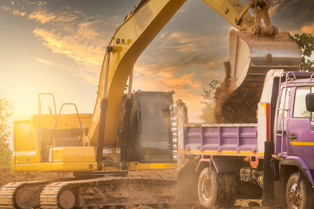 istock Backhoe working by digging soil at construction site and loading to the truck. Bucket of backhoe transport soil to truck. Crawler excavator dump dirt soil to heavy dump truck. Excavating machine. 1311213702