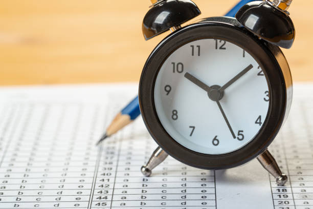 istock answer sheet, test in exercise and passing examination paper computer sheet with pencil alarm clock and pencil for education concept 1311214503