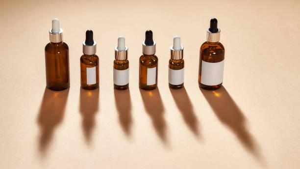 istock Many glass bottle cosmetics with dropper isolated on beige background 1311215716