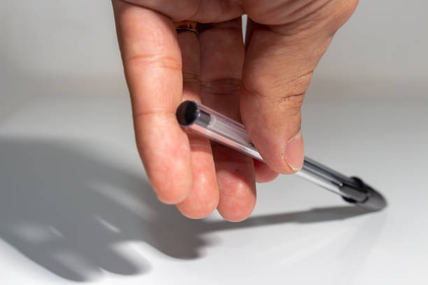 istock Male hand on white background holding black pen 1311216677