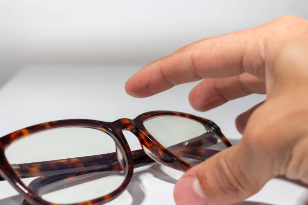 istock Male hand picking up brown glasses on white background 1311216678