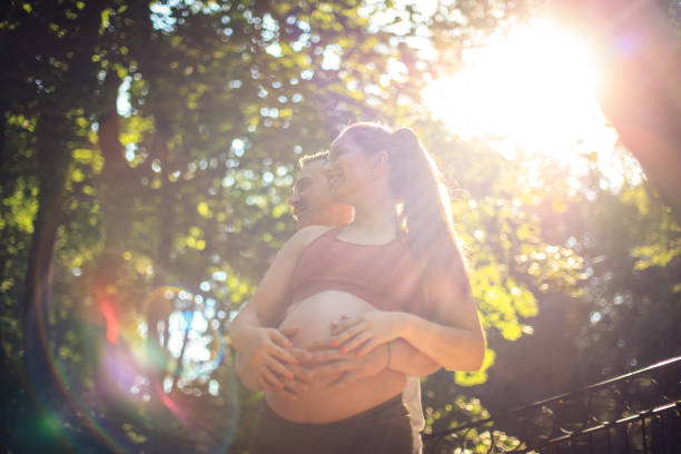 Sports couple standing in the park and touch the stomach.