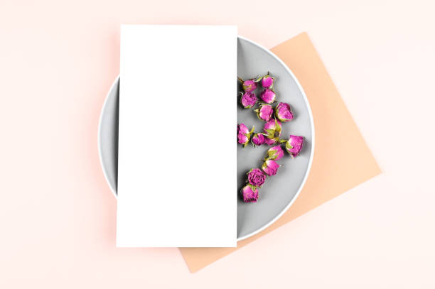 istock Vertical blank white card on circle stand and pastel paper, dried rose buds on background. Empty space. 1311217801