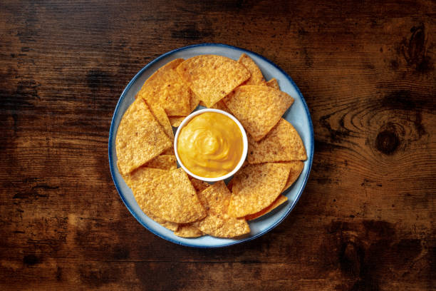 croustilles nacho avec trempette au fromage, projectile aérien - cheese sauce cheese tortilla chip nachos photos et images de collection