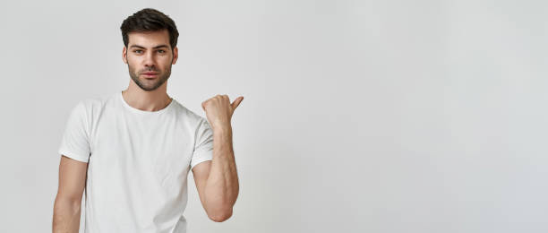 istock Man wearing t-shirt pointing thumb aside 1311220006